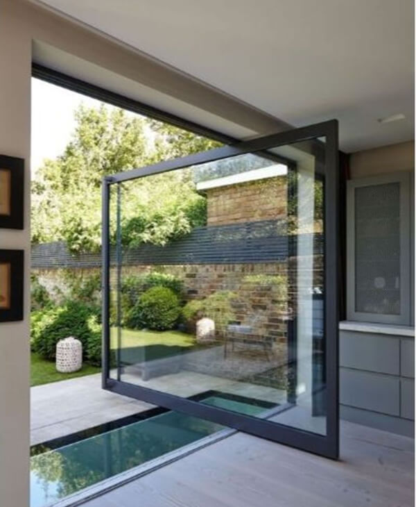 Cửa kính dạng xoay tách không gian phòng khách với sân vườn