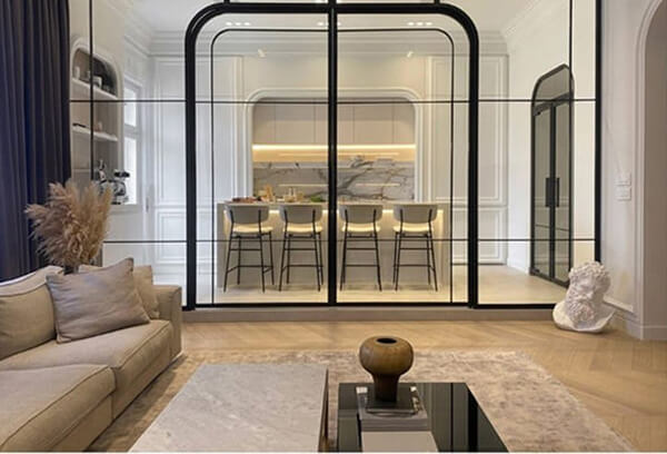 Vách kính với khung bo tròn tạo cảm giác mở, không bị bí giữa phòng khách và bếp