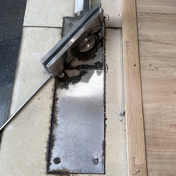 Bản lề của cửa kính cường lực bị xệ chạm xuống nền nhà